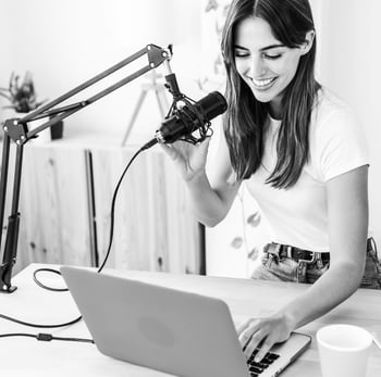 young woman sitting at table with laptop and microphone young woman sitting at table with laptop and microphone