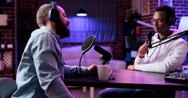 Male podcaster in front of mic, talking to unseen person